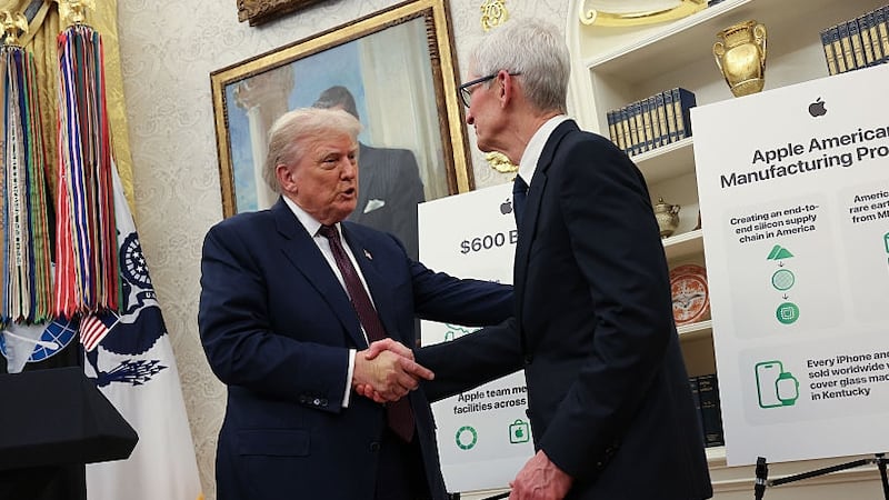WASHINGTON, DC - AUGUST 06: U.S. President Donald Trump (L) shakes hands with Apple CEO Tim Cook during an event in the Oval Office of the White House on August 6, 2025 in Washington, DC. Apple Inc. announced a $100 billion investment in manufacturing facilities in the U.S., on top of an announcement in February committing over the next four years to a $500 billion investment in the U.S. economy and the addition of 20,000 new jobs. (Photo by Win McNamee/Getty Images)