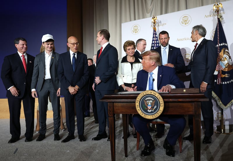 U.S. President Donald Trump looks to members of his cabinet and staff before signing an executive order during the America.gov launch event at Andrew W. Mellon Auditorium on September 29, 2026 in Washington, DC.