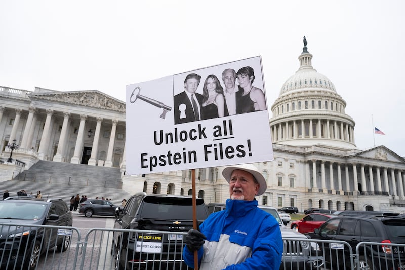 WASHINGTON, DC - NOVEMBER 18: A protester holds a placard after the House voted 427-1 to approve the Epstein Files Transparency Act and the release of documents and files at the U.S. Capitol on November 18, 2025 in Washington, DC. The legislation instructs the U.S. Department of Justice to release all files related to the late accused sex trafficker Jeffrey Epstein. It now goes to the Senate for a vote before President Donald Trump can sign it into law.   (Photo by Roberto Schmidt/Getty Images)