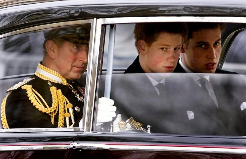 Prince Charles and his sons Prince Harry and Prince William arrive at Westminster Hall following the coffin of the Queen Mother to Westminster Abbey during her funeral procession on April 9, 2002.