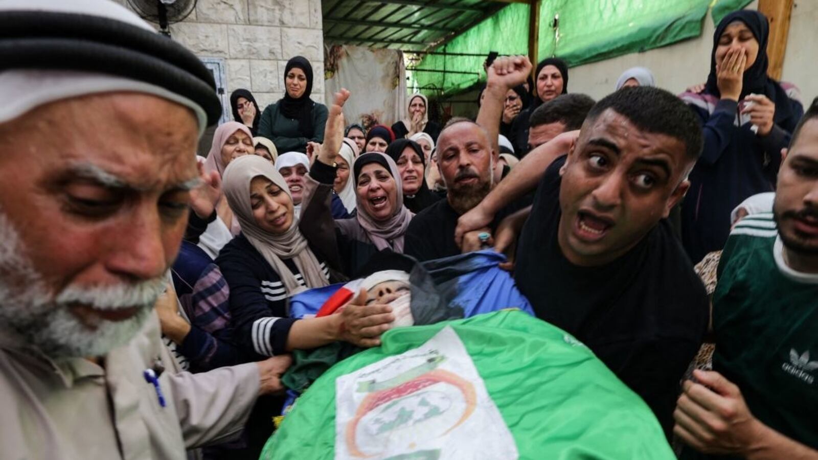 Mourners carry the flag-draped body of Mahmoud Abu Saan, a Palestinian teenager shot dead by Israeli forces in the occupied West Bank town of Tulkarm, during his funeral in the same town on Aug. 4, 2023.