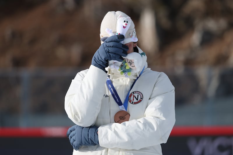 Bronze medalist Sturla Holm Laegreid of Team Norway reacts on the podium during the medal ceremony