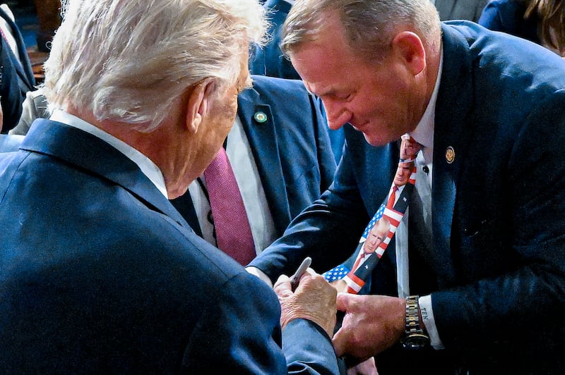 U.S. President Donald Trump signs the tie of Rep. Troy Nehls.