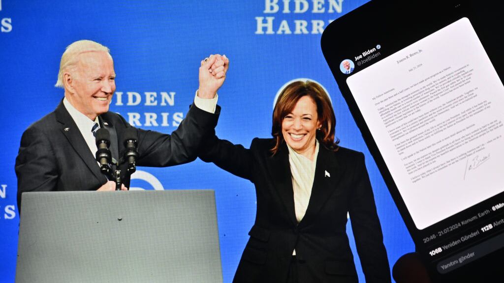 The letter in which U.S. President Joe Biden announced his withdrawal from candidacy is displayed on a mobile phone screen in front of a computer screen displaying a photo of President Biden and US Vice President Kamala Harris.