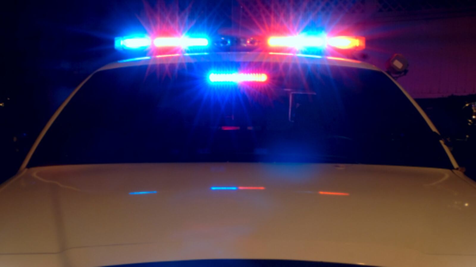 Police_car_with_emergency_lights_on_aoemwg