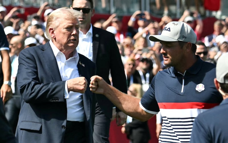 U.S. President Donald Trump fist-bumps pro-golfer Bryson DeChambeau as he attends the 45th Ryder Cup golf competition at Bethpage Black Golf Course in Farmingdale, New York, U.S., September 26, 2025. Mandel Ngan/Pool via REUTERS