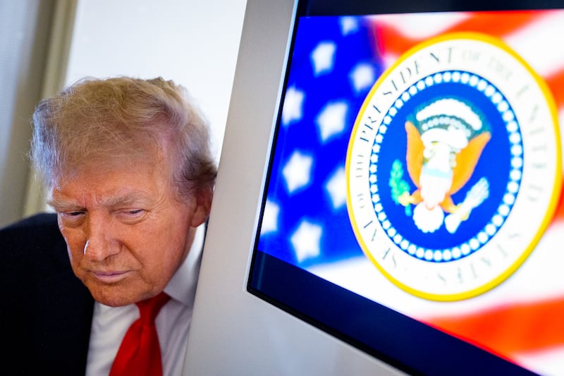 President Donald Trump takes a question from a reporter aboard Air Force One on August 15, 2025, in flight.