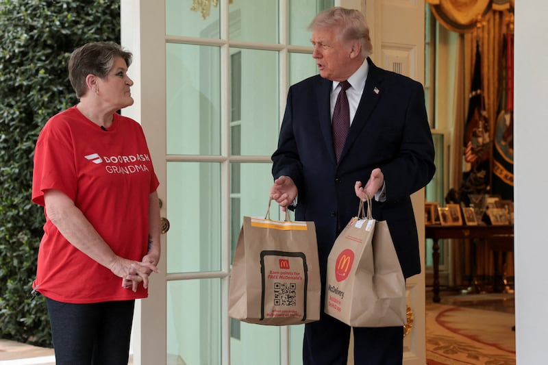 U.S. President Donald Trump holds McDonald's bags outside the Oval Office at the White House