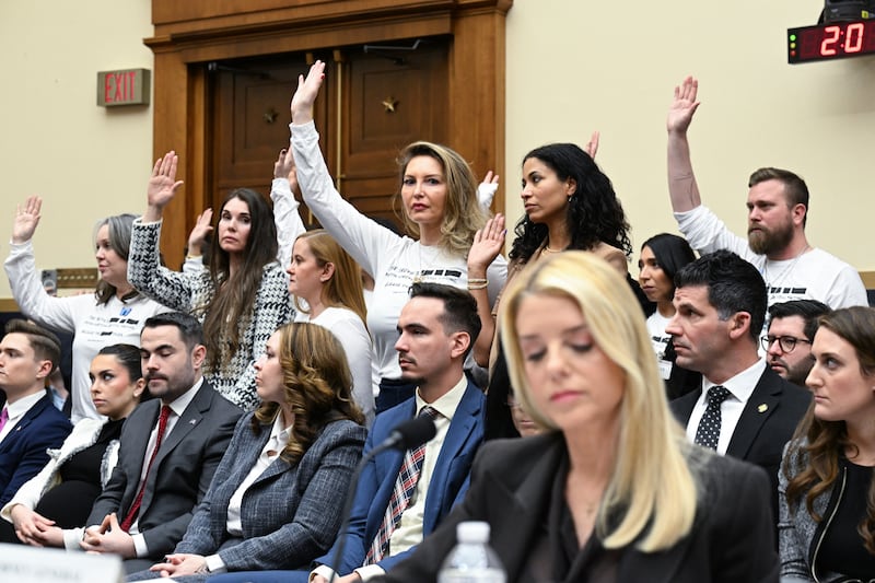 Survivors of convicted sex offender Jeffrey Epstein stand behind Attorney General Pam Bondi and raise their hands in a showing that they have still not been able to meet with her Justice Department moments after Bondi claimed they would take accusations seriously.