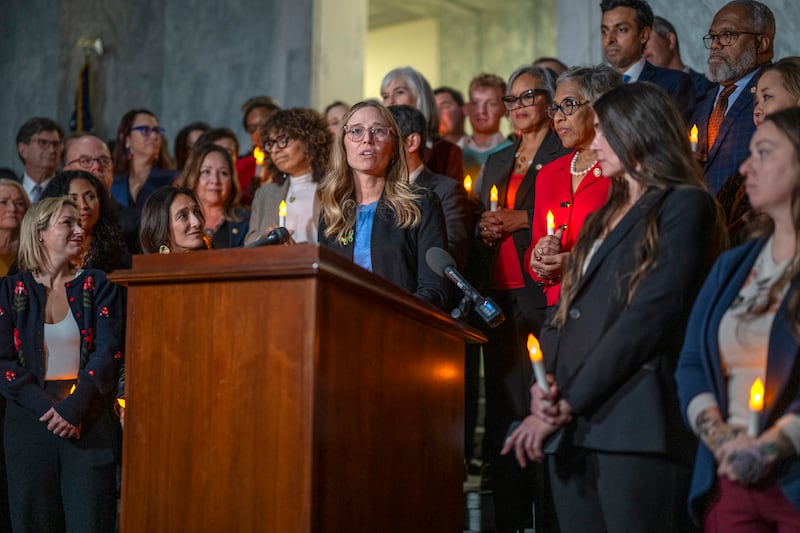 Annie Farmer, a victim of Epstein, speaks from the podium during a candlelight vigil to honor survivors of his crimes in Washington, DC, last November. All but one member of Congress voted to compel the release of the Epstein files.