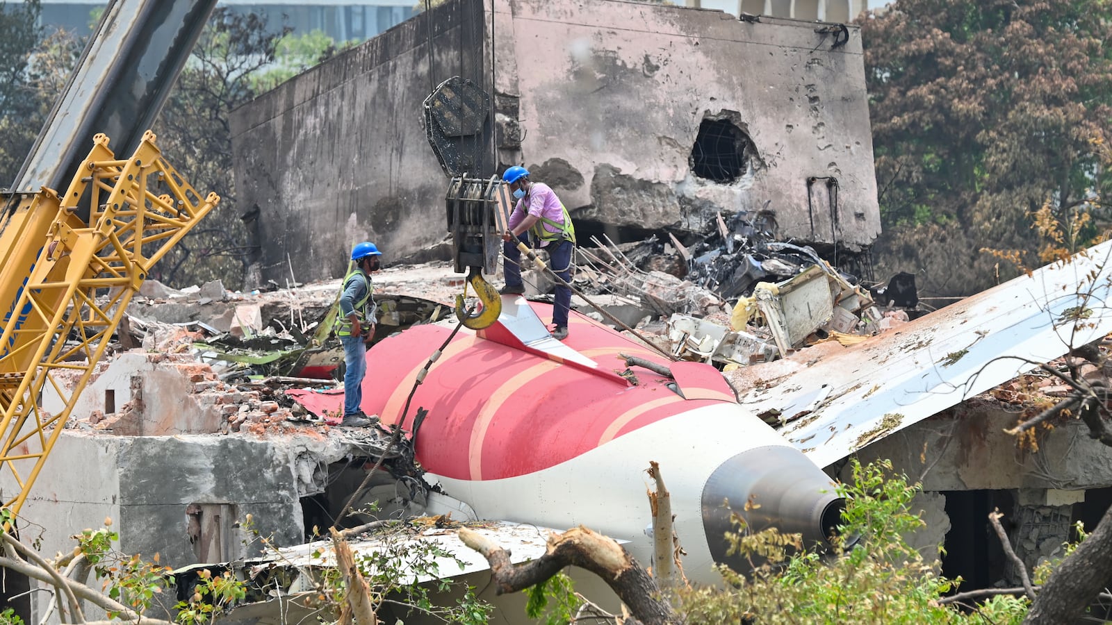AHMEDABAD, INDIA - JUNE 14: The wreckage of the crashed Air India plane is being lifted by a crane