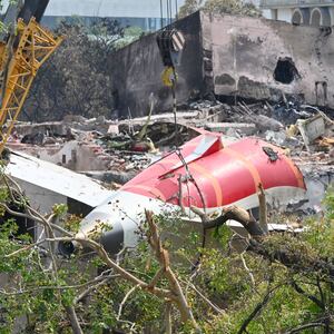 The wreckage of the crashed Air India plane is being lifted by a crane from the roof of the BJ Medical College mess building, on June 14, 2025 in Ahmedabad, India.