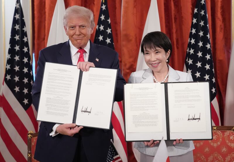 Trump and Takaichi hold up signed documents for a critical minerals/rare earth deal between the U.S. and Japan.