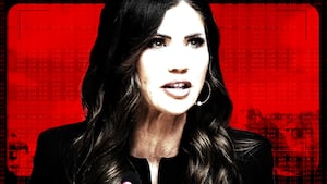 Kristi Noem in front of a camera view of her DHS ad campaign.