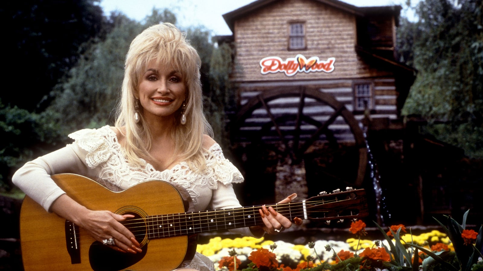 Dolly Parton poses for a portrait with her guitar at Dollywood circa 1993 in Pigeon Forge, Tennessee.