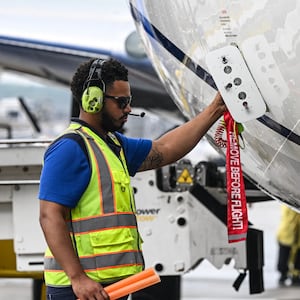 Workers of United Airlines prepare a plane to take off at George Bush Intercontinental Airport on July 25, 2025, in Houston, Texas. (Photo by RONALDO SCHEMIDT / AFP) (Photo by RONALDO SCHEMIDT/AFP via Getty Images)