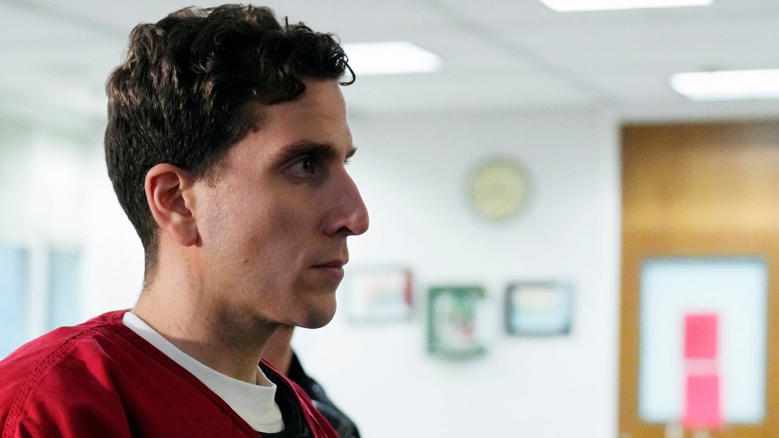 Bryan Kohberger, wearing a red prison jumpsuit, stares forward.