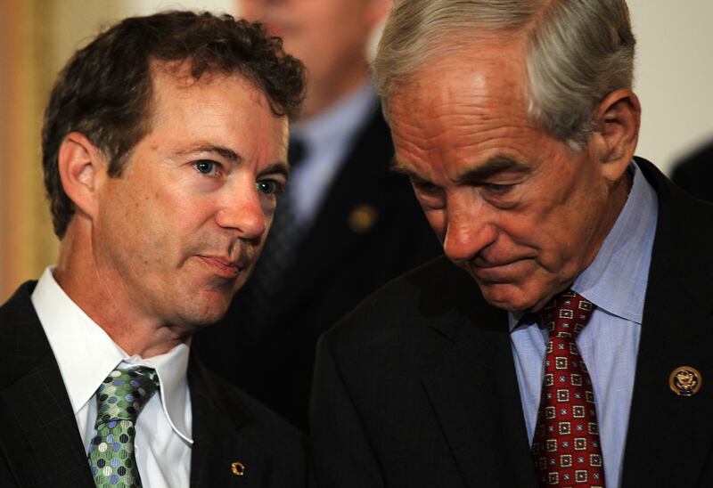 U.S. Sen. Rand Paul (R-KY) (L) talks to his father Rep. Ron Paul (R-TX) (R) during a news conference