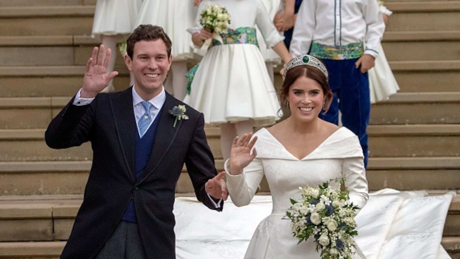 Princess Eugenie of York (R) and her husband Jack Brooksbank wave as they emerge from the West Door of St George's Chapel, Windsor Castle, in Windsor, on October 12, 2018 after their wedding ceremony.