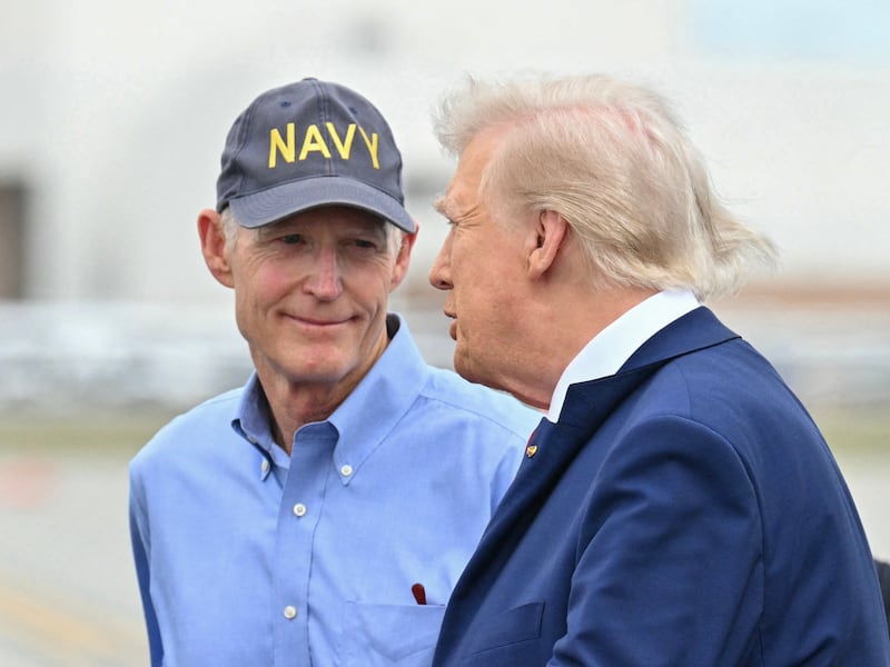 US President Donald Trump (R) speaks with US Senator Rick Scott (2nd R), Republican from Florida, and others upon arrival at Daytona Beach International Airport, enroute to the Daytona 500 NASCAR race in Daytona Beach, Florida, on February 16, 2025. (Photo by ROBERTO SCHMIDT / AFP via Getty Images)
