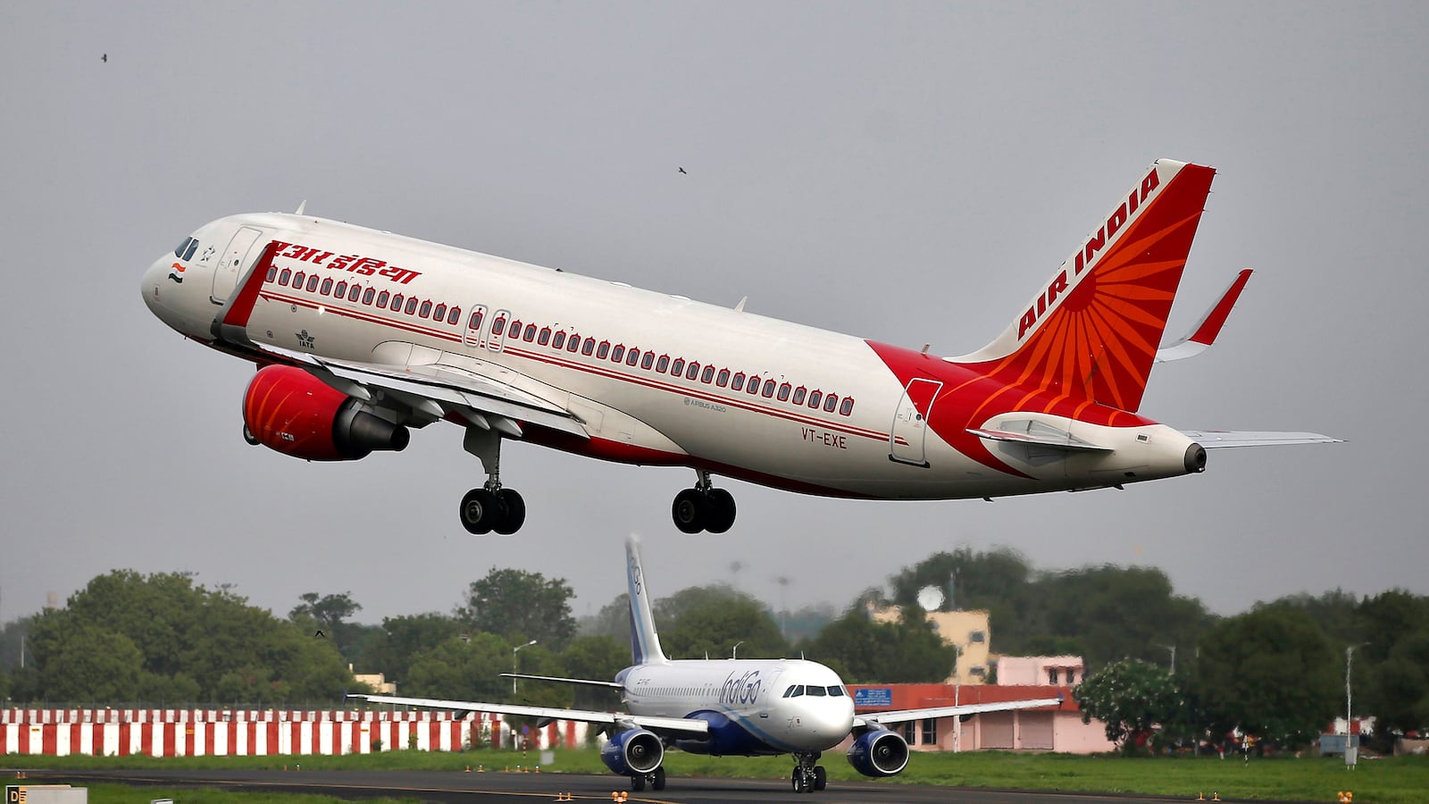 An Air India Airbus A320-200 aircraft takes off as an IndiGo Airlines aircraft waits for clearance at the Sardar Vallabhbhai Patel International Airport in Ahmedabad, India, July 7, 2017.