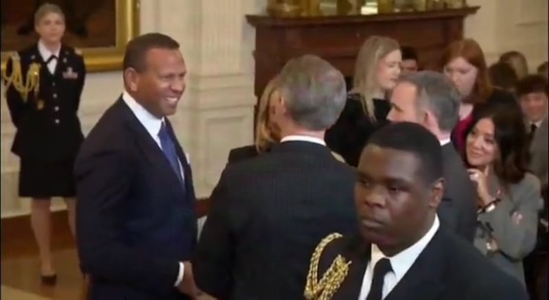 The under-fire secretary gazes at the former MLB star.