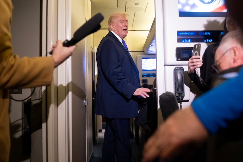 President Donald Trump speaks to members of the media aboard Air Force One.
