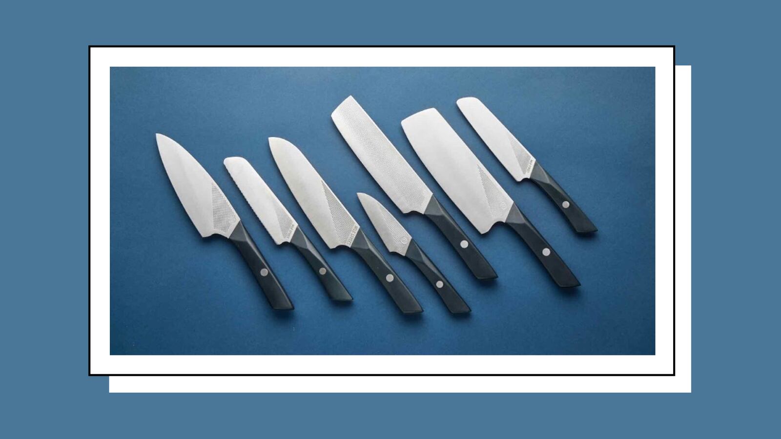 As assortment seven different knives of various sizes. The knives all have black handles and are laying on a dark blue surface.