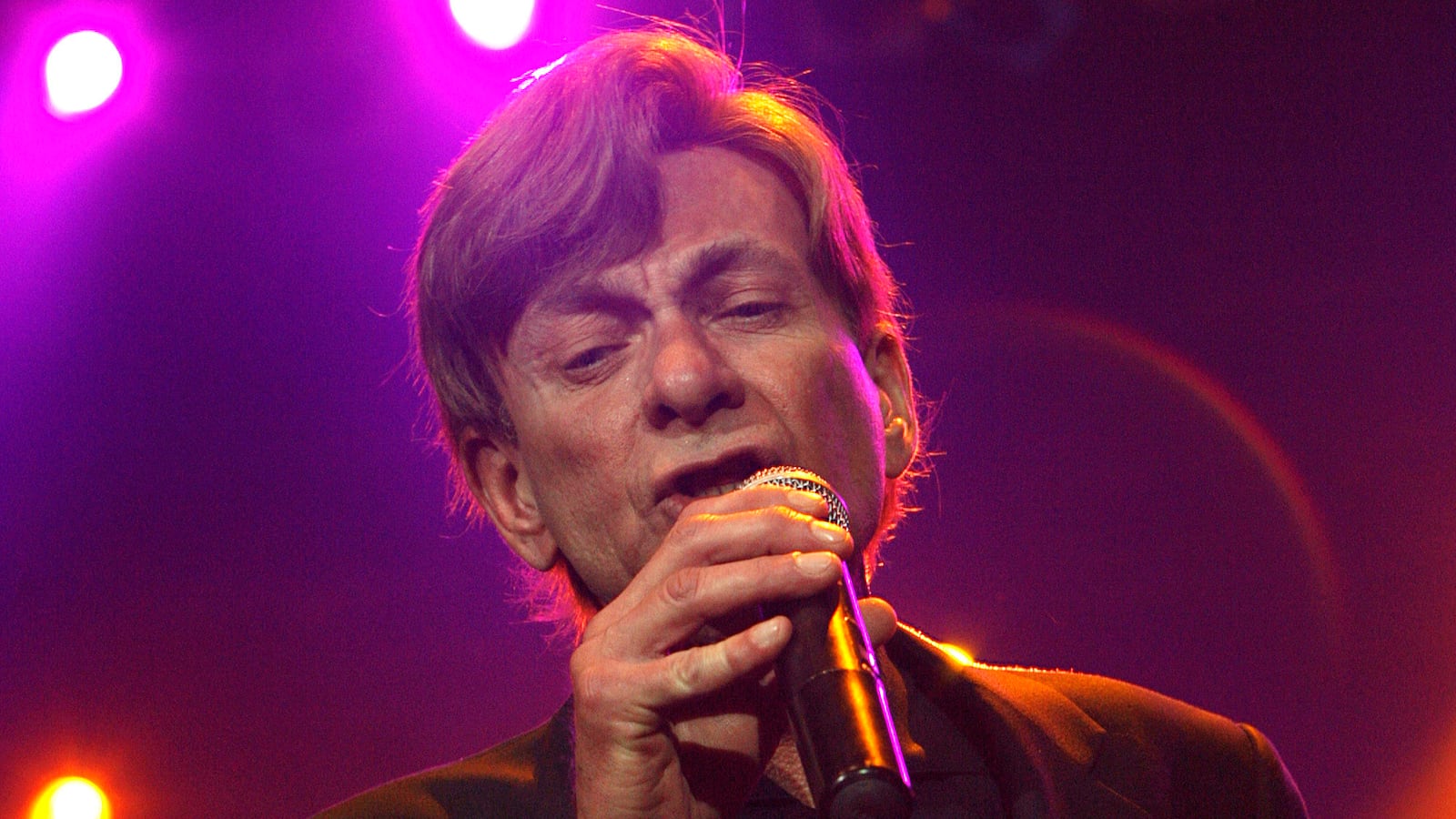 Bobby Caldwell performs in a neon-lit room