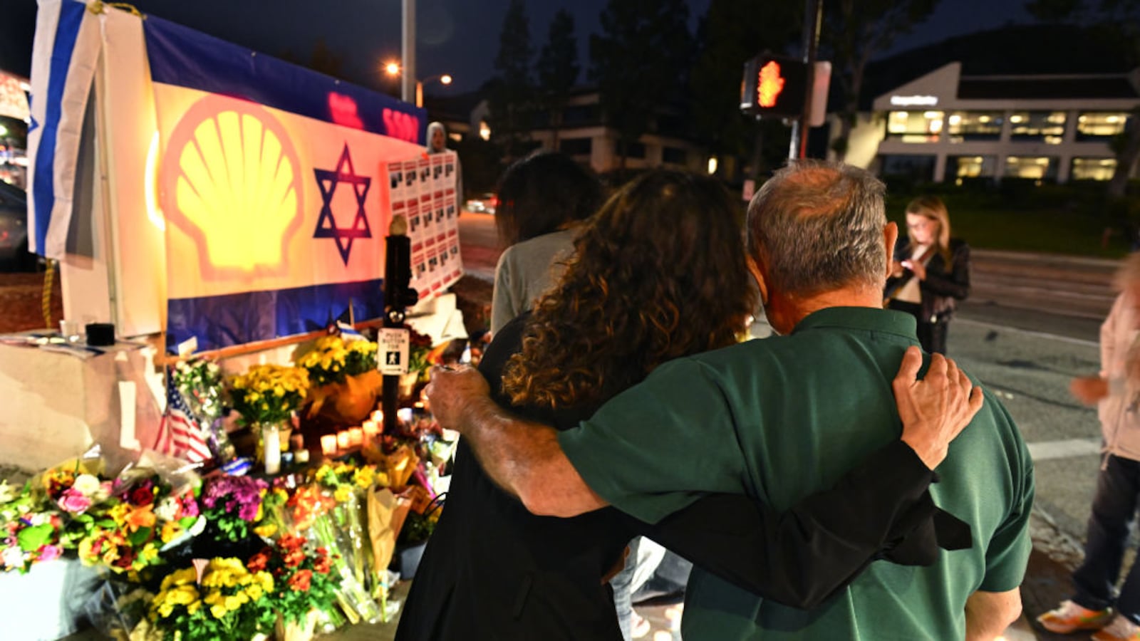 Mourners embraced by an Israeli flag at a memorial for Paul Kessler.