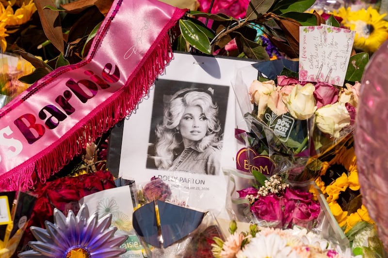 Flowers and other items in memory of Dolly Parton are left at the entry gate of Parton’s home following the passing of the country music icon, who died aged 80, in Brentwood, Tennessee, U.S., August 27, 2026. REUTERS/Seth Herald