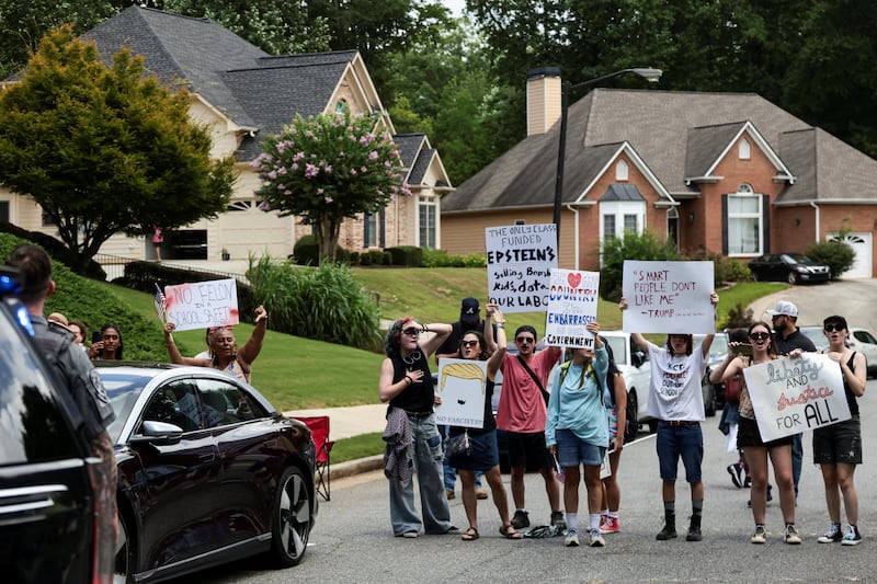 Protesters gather along the route of a motorcade carrying U.S. President Donald Trump as he travels to deliver remarks on the "Trump Accounts" tax-advantaged investment program at Wheeler High School in Marietta, Georgia, U.S., July 22, 2026. REUTERS/Evelyn Hockstein