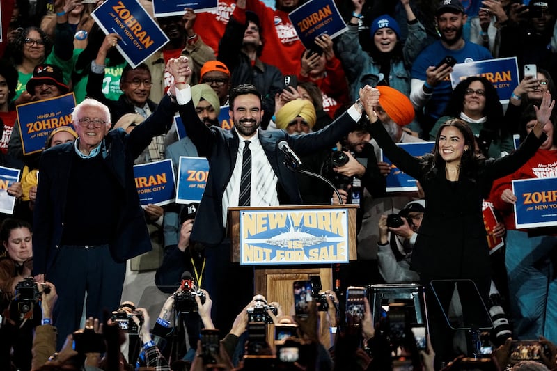 New York City mayoral candidate Zohran Mamdani, U.S. Senator Bernie Sanders (I-VT) and U.S. Representative Alexandria Ocasio-Cortez (D-NY) react on stage during a "New York is Not For Sale" rally at Forest Hills Stadium, in the Queens borough of New York City, U.S., October 26, 2025.