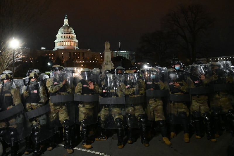 National Guard troops clear a street from protestors outside the Capitol building on January 6, 2021 in Washington, DC. - Donald Trump's supporters stormed a session of Congress held today, January 6, to certify Joe Biden's election win, triggering unprecedented chaos and violence at the heart of American democracy and accusations the president was attempting a coup.