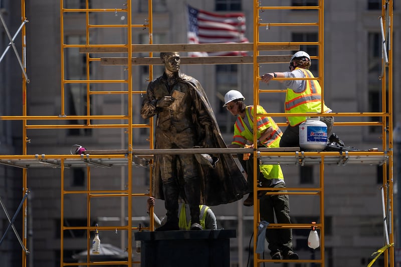 Workers add a gold finish to statues in Freedom Plaza near the White House, ahead of America 250, in Washington, D.C., U.S., June 3, 2026. REUTERS/Nathan Howard