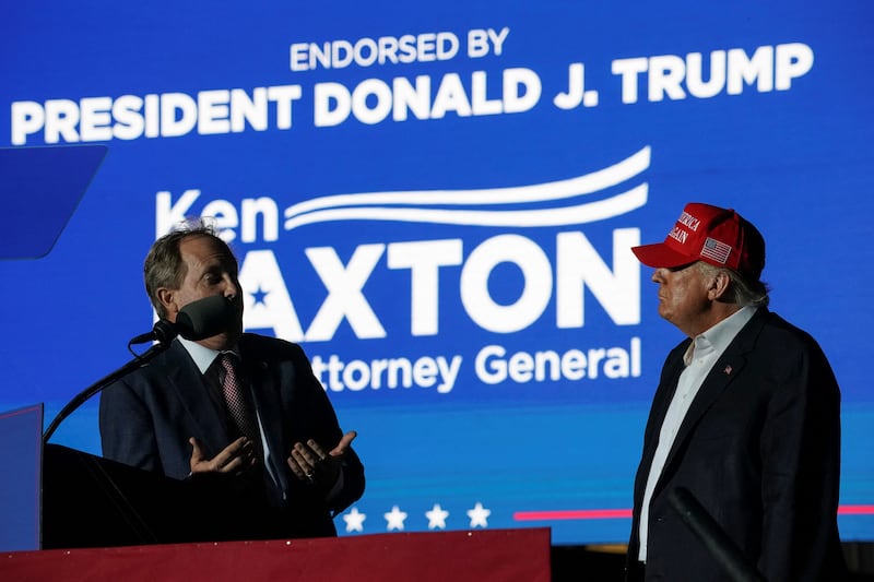 Former U.S. President Donald Trump listens as Texas Attorney General Ken Paxton speaks during a rally in Robstown, Texas, U.S., October 22, 2022. REUTERS/Go Nakamura