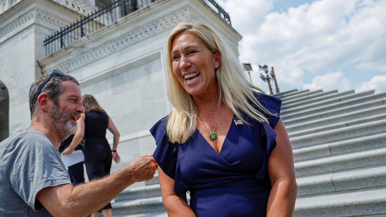 U.S. Representative Marjorie Taylor Greene (R-GA) smiles after taking a selfie with a visitor on the Capitol steps after a vote at the U.S. Capitol in Washington.