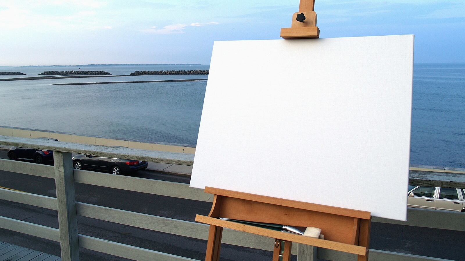 Easel with empty canvas looking out on the water.
