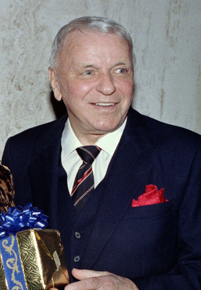 Legendary entertainer Frank  Sinatra holds a gift as he celebrates his 80th birthday December 12 prior to an intimate dinner party at the Beverly Hills home of television producer George   Schlatter and his wife Jolene. Mr. and Mrs. Sinatra were joined by guests at the party Gregory and Veronique Peck and Kirk and Anne Douglas