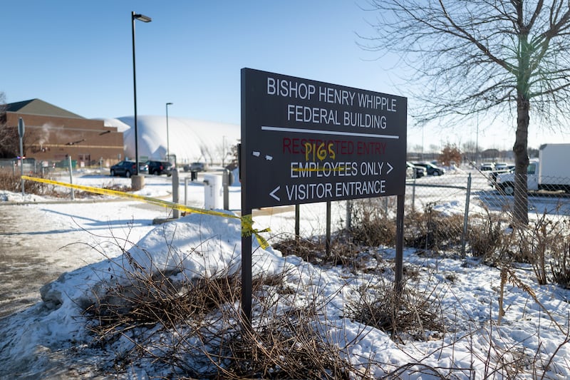 Activists stand outside the Bishop Henry Whipple Federal Building
