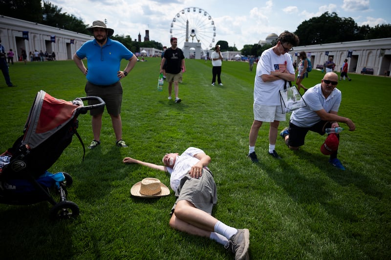An attendee rests on the grass during The Great American State Fair on the National Mall, Thursday, June 25, 2026 in Washington, D.C.
