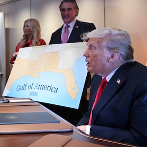 President Donald Trump speaks to reporters next to a map of the newly renamed Gulf of America on Air Force One.