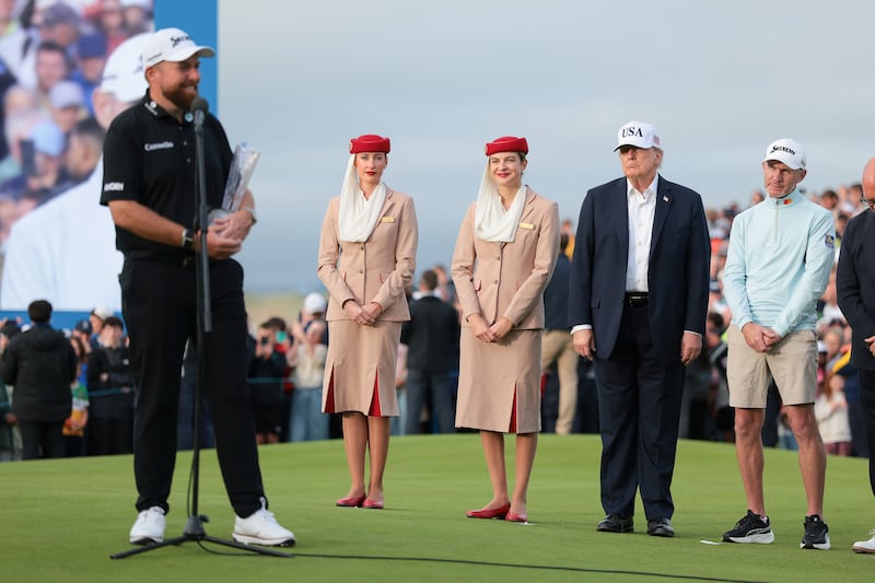 U.S. President Donald Trump watches as Irish golfer Shane Lowry speaks while holding the Amgen Irish Open trophy, at Trump International Golf Links in Doonbeg, Ireland, September 13, 2026. REUTERS/Kylie Cooper