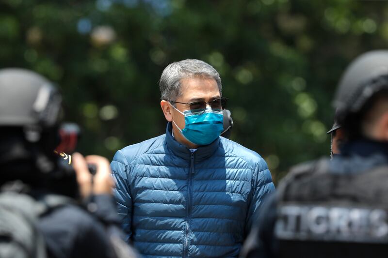 TEGUCIGALPA, HONDURAS - APRIL 21: Former President of Honduras Juan Orlando Hernandez is escorted by Members of the Police Special Forces to be extradited to U.S.to face charges of taking bribes from drug traffickers at Honduran National Directorate of Special Forces on April 21, 2022 in Tegucigalpa, Honduras. Hernandez will stand trial for allegedly aiding the smuggling of hundreds of tons of cocaine to America (Photo by Jorge Cabrera/Getty Images)
