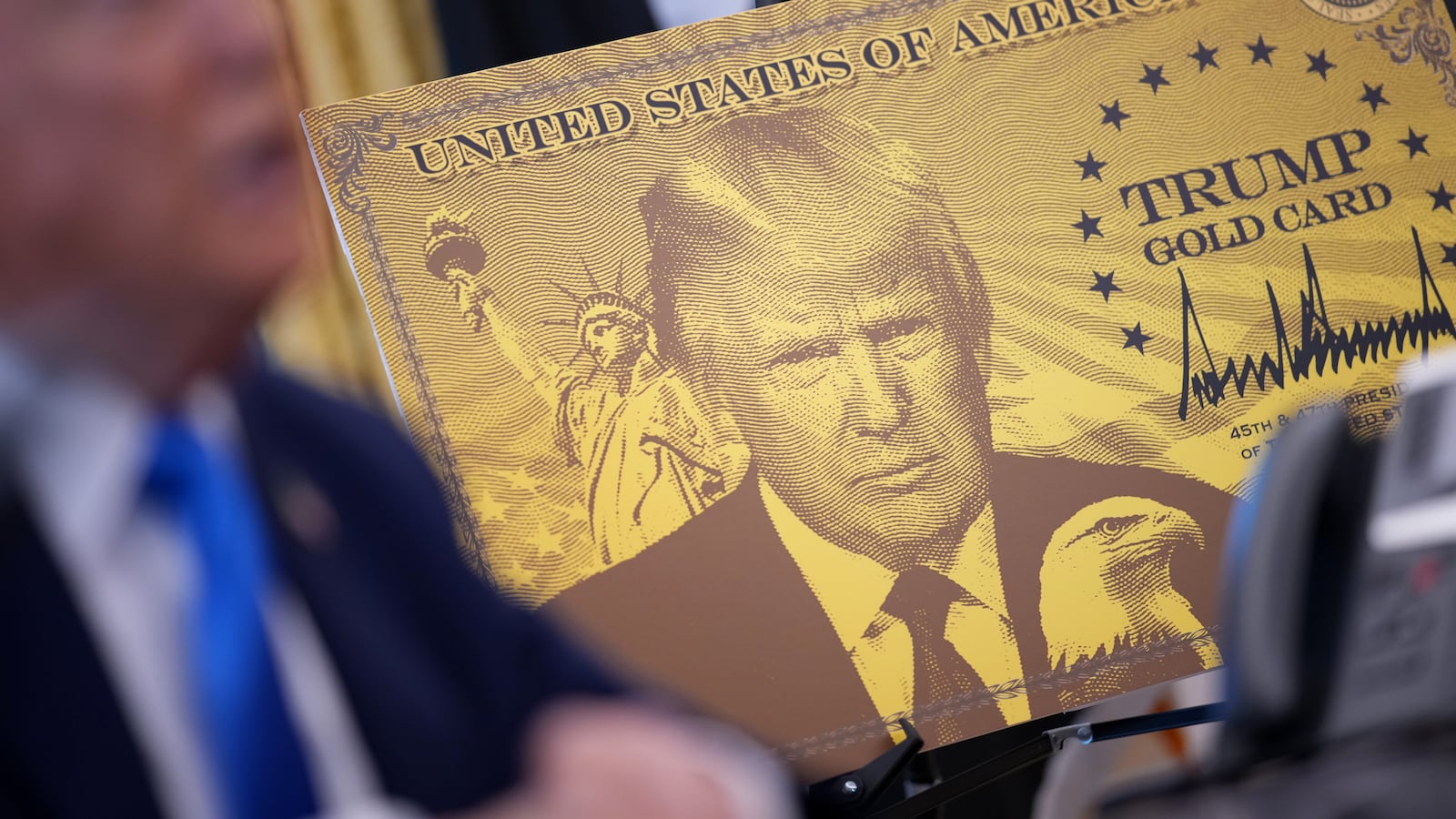 WASHINGTON, DC - SEPTEMBER 19: A poster of the “Trump Gold Card” is seen as President Donald Trump delivers remarks in the Oval Office at the White House on September 19, 2025 in Washington, DC. The “Trump Gold Card” is a visa that allows foreign nationals permanent residency and a pathway to U.S. citizenship for a $1 million investment in the United States. (Photo by Andrew Harnik/Getty Images)