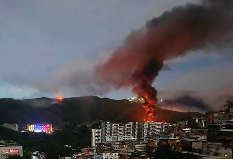 Fire at Fuerte Tiuna, Venezuela's largest military complex, is seen from a distance after a series of explosions in Caracas on January 3, 2026. The United States military was behind a series of strikes against the Venezuelan capital Caracas on Saturday, US media reported. The White House and Pentagon have not commented on the explosions and reports of aircraft over the city.