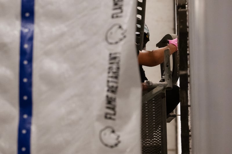 A worker removes a letter from the Kennedy Center's front sign, as crews enforce a court order to take President Donald Trump's name off the building early morning on June 13, 2026 in Washington, DC.