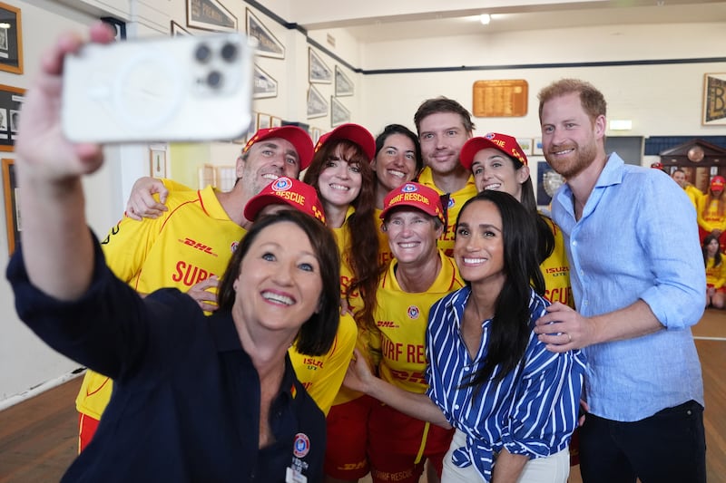 Meghan, Duchess of Sussex and Prince Harry, Duke of Sussex pose for a selfie photo as they meet volunteer first responders from Bondi Surf Bathers' Life Saving Club, during a visit to Bondi Beach, on day four of the royal trip to Australia on April 17, 2026 in Sydney, Australia. Volunteers from the organization, founded in 1907, played an integral role in protecting beachgoers and saving lives during the terrorist attack at Bondi Beach on December 14.