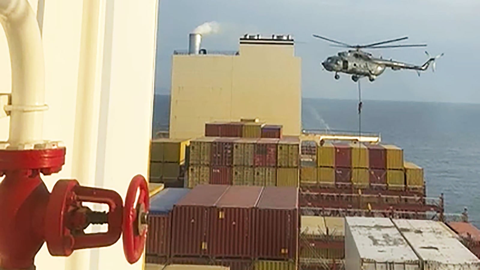 This image made from a video provided to The Associated Press by a Mideast defense official shows a helicopter raid targeting a vessel near the Strait of Hormuz on Saturday, April 13, 2024.