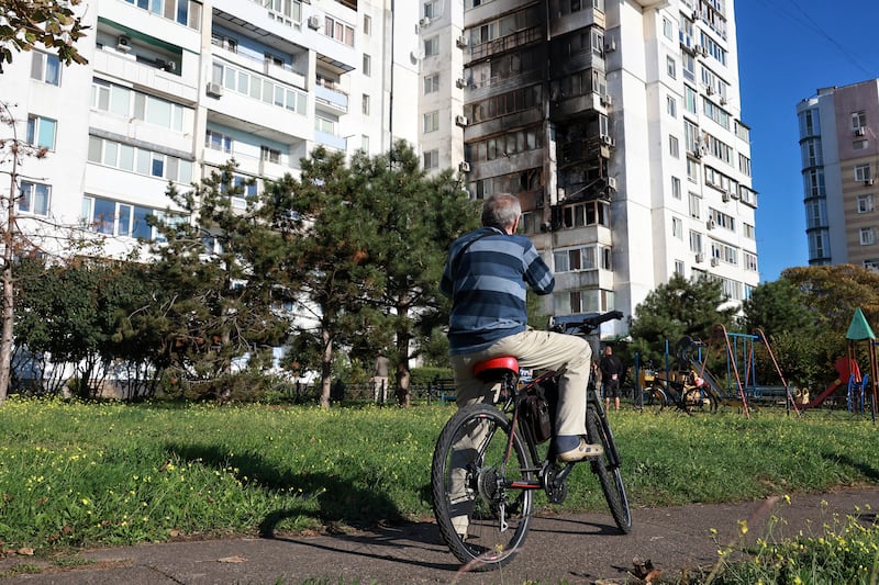 A man on a bicycle looks at a residential building damaged in a night attack by Russian kamikaze drones, Chornomorsk, Odesa region, southern Ukraine.